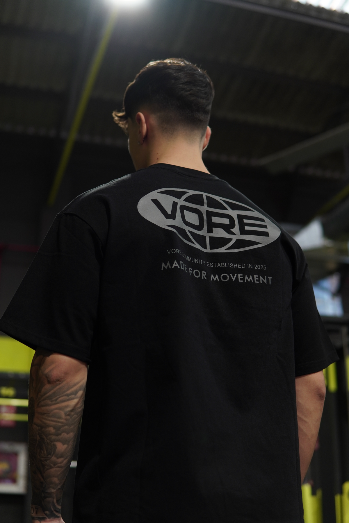 Camiseta oversize VORE negra en el gimnasio